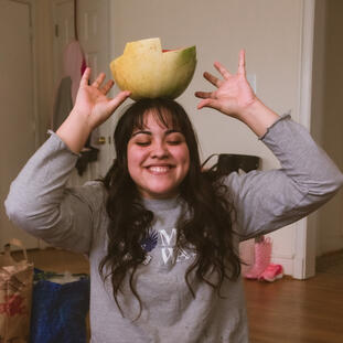 young woman balancing watermelon on top of head